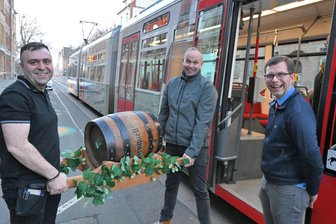 Zwickau: Straßenbahn transportiert auf Sonderfahrt ein Bierfass - Vasilis Karakesisian vom Griechischen Restaurant „Korfu“ (l.) freut sich über das Bierfass, das Torsten Müller, Gebietsverkaufsleiter bei der Sternquell-Brauerei (Mitte), und SVZ-Betriebsleiter Steffen Schranil mit der Bahn vorbeigebracht haben.