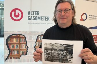 Zwickauer Geschichtswerkstatt: Zeitzeuginnen aus dem VEB Sachsenring gesucht - Jörg Banitz von der Zwickauer Geschichtswerkstatt mit einem Foto, das Frauen im VEB Sachsenring zeigt.