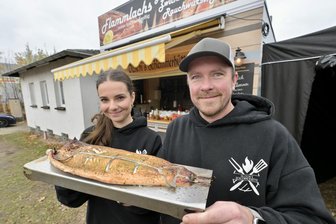 Zwickauer Imbiss serviert Flammlachs, Haxenfetzensemmel und mehr: „Wir wollten weg von klassischer Grillware“ - Anna-Lena Dienel und Sebastian Olzscha servieren in ihrer Imbisshütte in Zwickau unter anderem Flammlachs.
