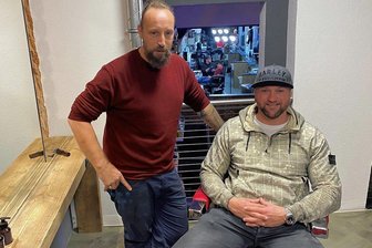 Zwickauer Star-Tätowierer Randy Engelhard hat nun einen Friseur an seiner Seite - Randy Engelhard rechts im Stuhl mit Basecap. Links neben ihm seine neue "Verstärkung" in der Lifestyle-Passage an der Peter-Breuer-Straße, Friseur Marcus Licht.