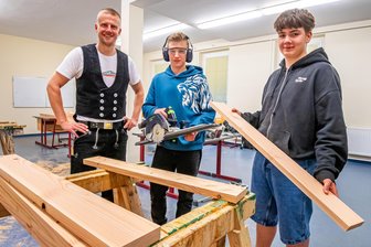 Zwischen Handkreissäge und Schlaraffenland: Ein besonderer Tag für die Achtklässler an der Olbernhauer Oberschule - Zimmerer Robin Scharf, Maximilian Wendrock und Louis Neo Pehns (v. l.) bauen ein Hochbeet.