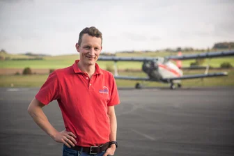 Zwischen Rost und Revolution: Jahnsdorfer Landeplatz soll Vorreiter für grünes Fliegen werden - Geschäftsführer Robert Rahnfeld will den Jahnsdorfer Flugplatz mit grünem Fliegen zukunftssicher machen. „Wir wären deutschlandweit mit ganz vorn dabei“, sagt er zu dem Vorhaben des Investors Evia Aero. Im Hintergrund: eine alte Antonov.