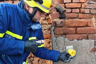 Zwölf-Stunden-Einsatz: Ein Brandhelfer erzählt - Ein Helfer vom THW Reichenbach bereitet die Messung der beschädigten Hauswand vor. An die Wand werden kleine Spiegel angebracht. Anhand ihrer Bewegung wird ermittelt, wie stabil das Gemäuer noch ist.